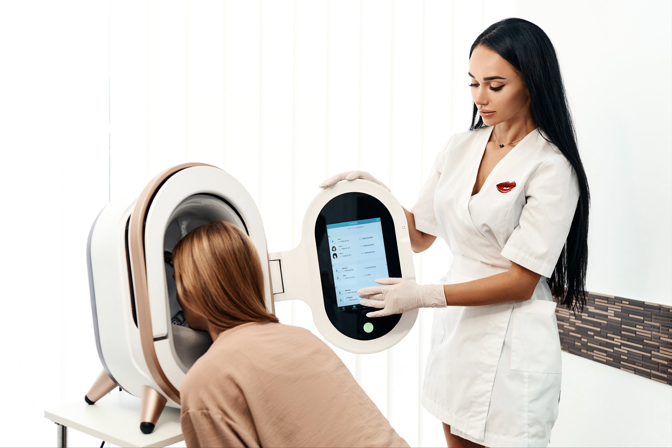 Woman receiving a hair treatment in a salon with a hairdresser operating a device.