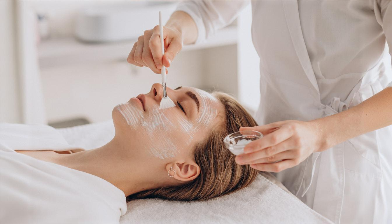 Person receiving a facial treatment with a skincare professional applying product.